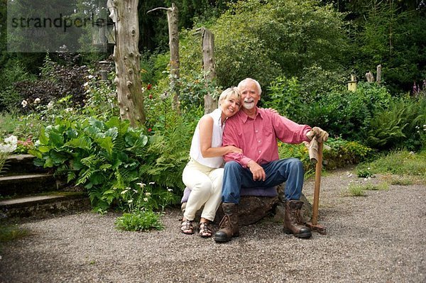Porträt eines älteren Paares  das im Garten sitzt