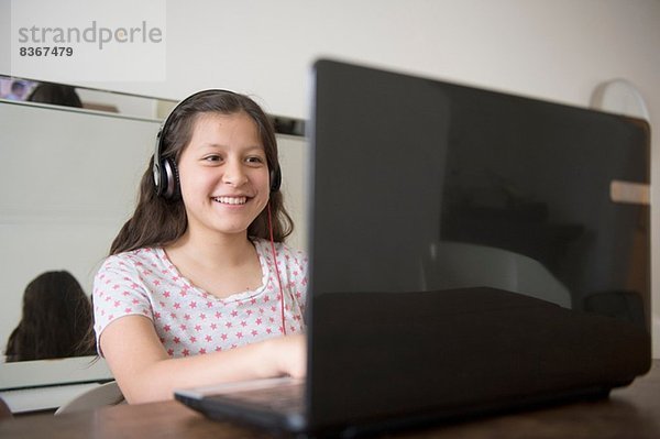 Teenager Mädchen mit Kopfhörer mit Laptop