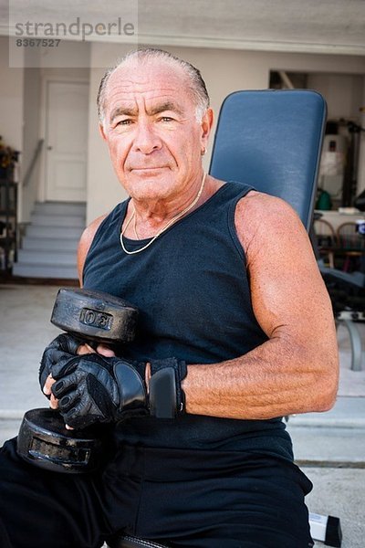 Porträt eines muskulösen älteren Mannes mit Hanteln