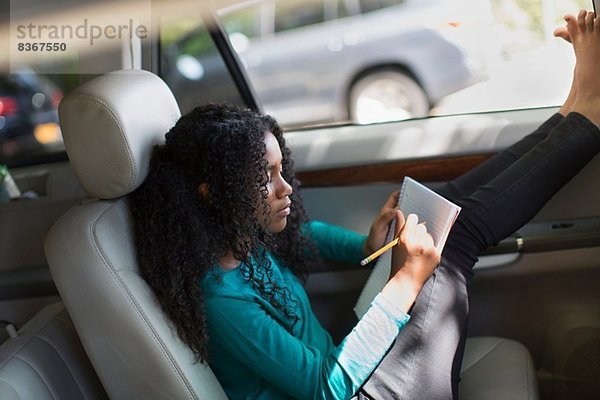 Junges Mädchen im Auto bei den Hausaufgaben