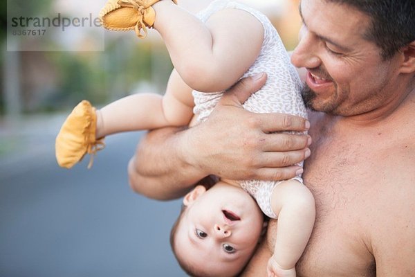 Großvater hält Baby-Enkelin auf den Kopf gestellt