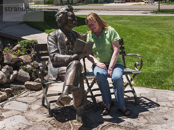 Vereinigte Staaten von Amerika  USA  Außenaufnahme  Frau  sitzend  Markierung  Statue  Sitzbank  Bank  Bibliotheksgebäude  Flussdelta  Delta  Utah