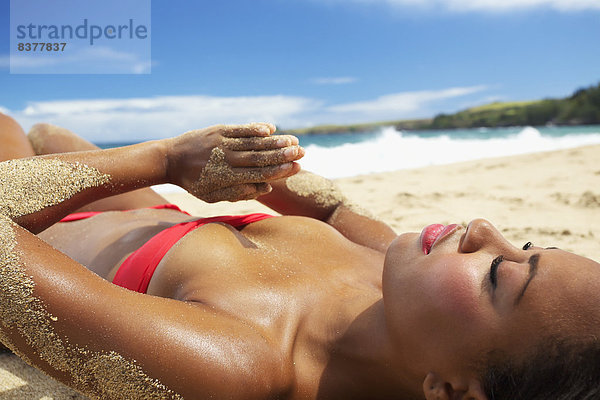 Vereinigte Staaten von Amerika  USA  Frau  liegend  liegen  liegt  liegendes  liegender  liegende  daliegen  Ecke  Ecken  Strand  Bikini  Sand  rot  jung  Hawaii  Maui