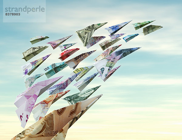 Verschiedene Währungen fliegen als Papierflieger