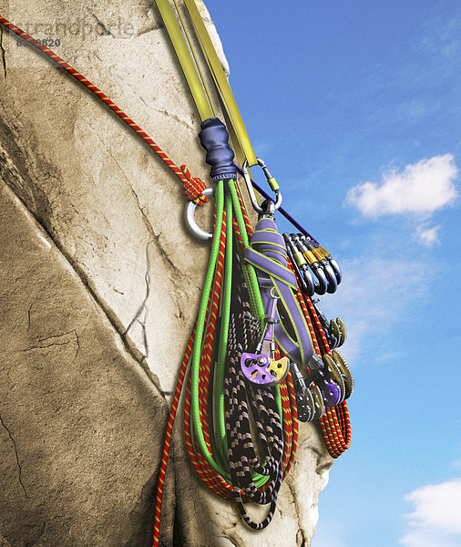 Karabiner und Seile hängen von einer Kletterwand