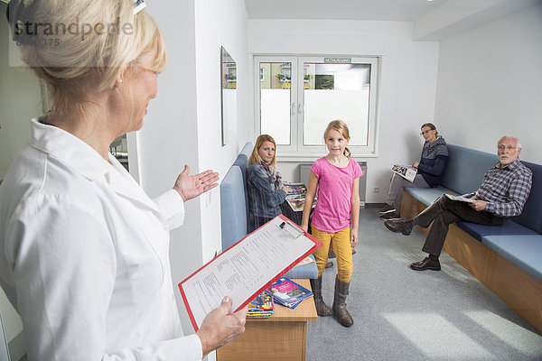 Sprechstundenhilfe ruft eine Patientin auf  Wartezimmer in einer Zahnarztpraxis  Deutschland