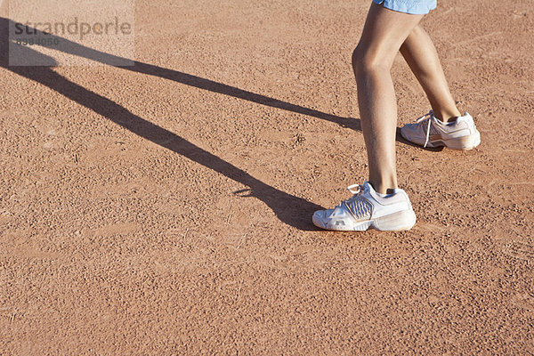 Kind steht auf dem Tennisplatz  niedrige Sektion