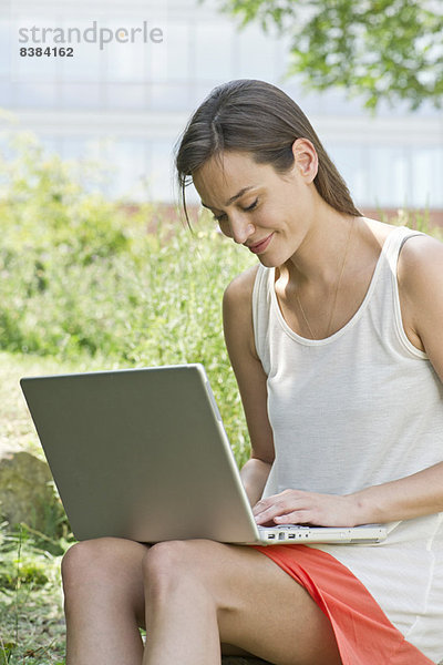 Frau mit Laptop im Freien
