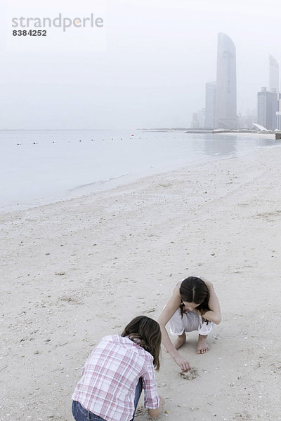 Mädchen auf der Suche nach Muscheln am Strand