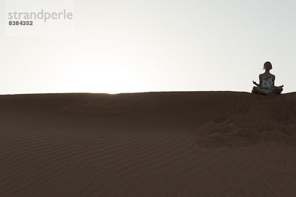 Mädchen meditieren in der Wüste
