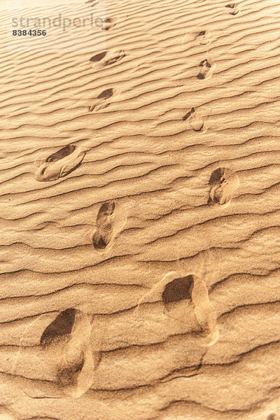Fußabdrücke im geriffelten Sand