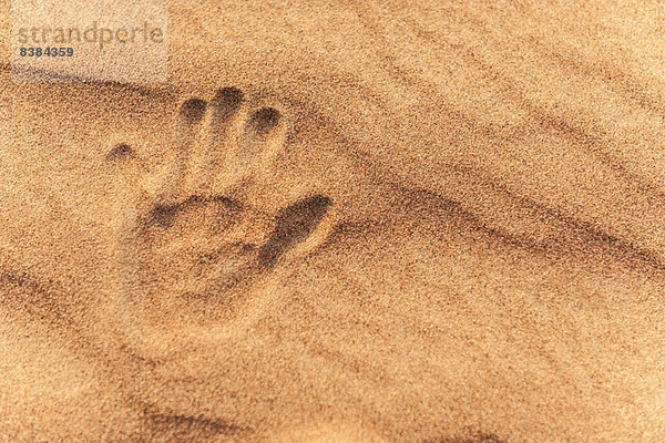 Handabdruck in Sand