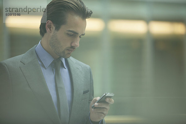 Geschäftsmann mit Handy im Büro