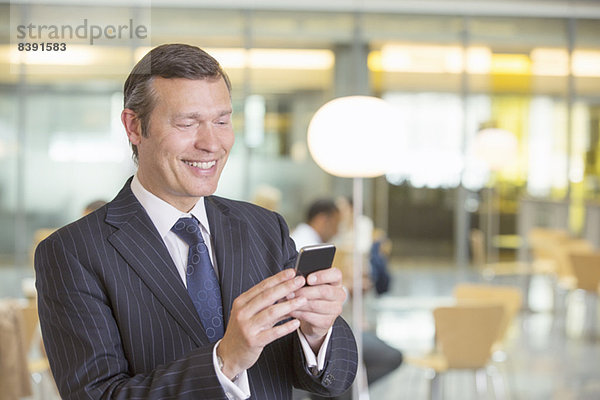 Geschäftsmann mit Handy im Büro