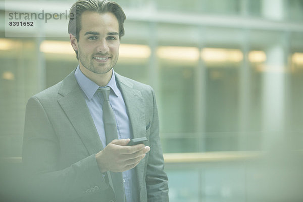 Geschäftsmann mit Handy im Büro