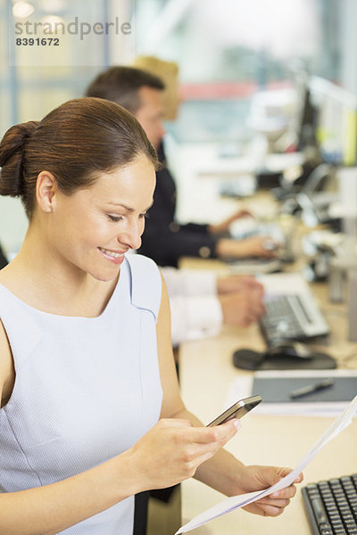 Geschäftsfrau mit Handy im Büro