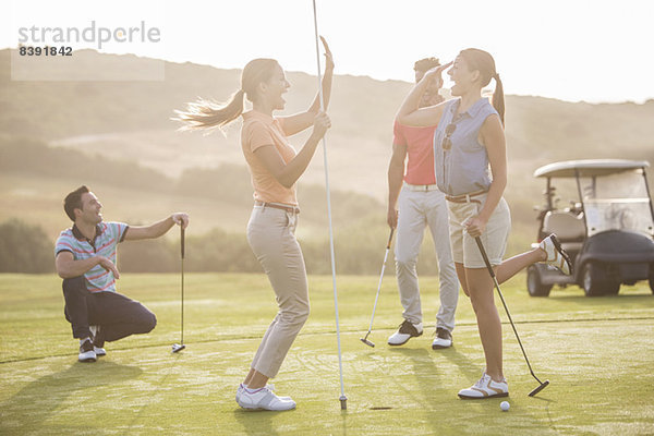 Frauen High Fiving auf dem Golfplatz