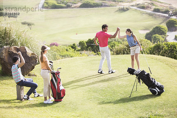 Freunde spielen Golf auf dem Platz