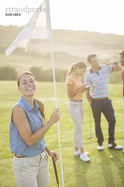 Lächelnde Frau mit Golfflagge