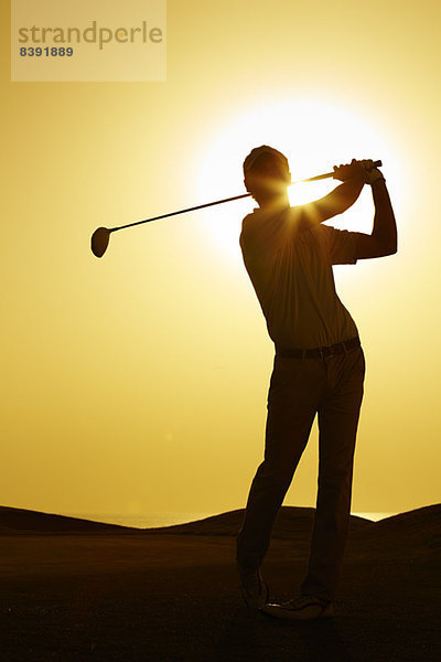 Silhouette des Mannes schwingender Golfschläger