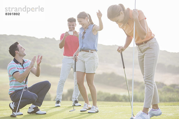 Freunde spielen Golf auf dem Platz