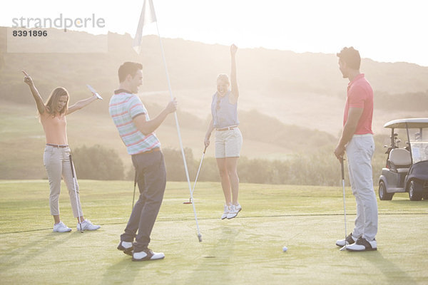 Begeisterte Freunde auf dem Golfplatz