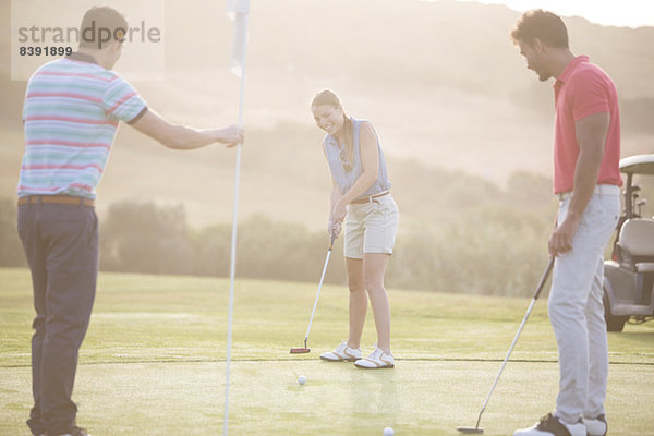 Freunde spielen Golf auf dem Platz