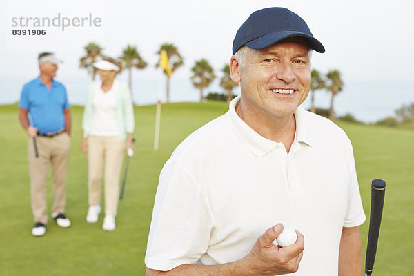 Lächelnder älterer Mann auf dem Golfplatz