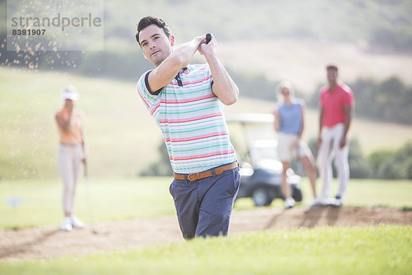 Freunde spielen Golf auf dem Platz