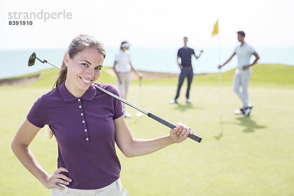 Frau lächelt auf dem Golfplatz