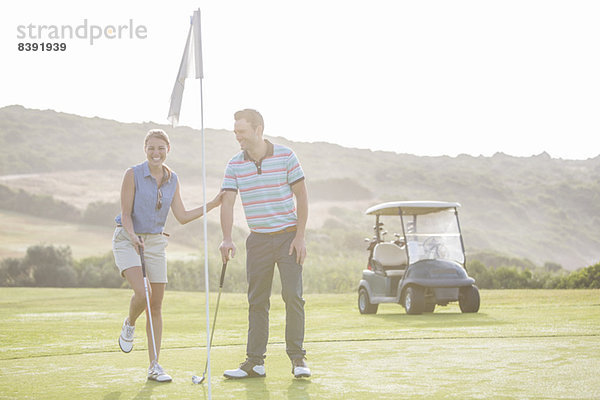 Paar spielt Golf auf dem Platz