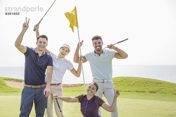 Begeisterte Freunde winken auf dem Golfplatz