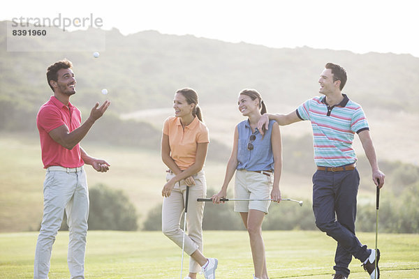 Freunde jonglierende Golfbälle auf dem Golfplatz