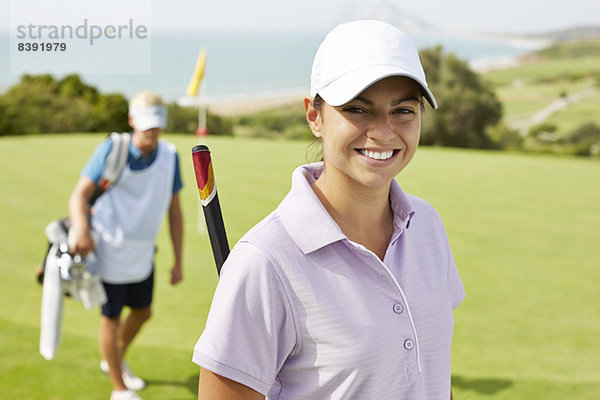 Lächelnde Frau auf dem Golfplatz