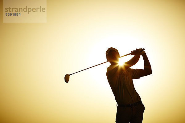 Silhouette des Mannes schwingender Golfschläger