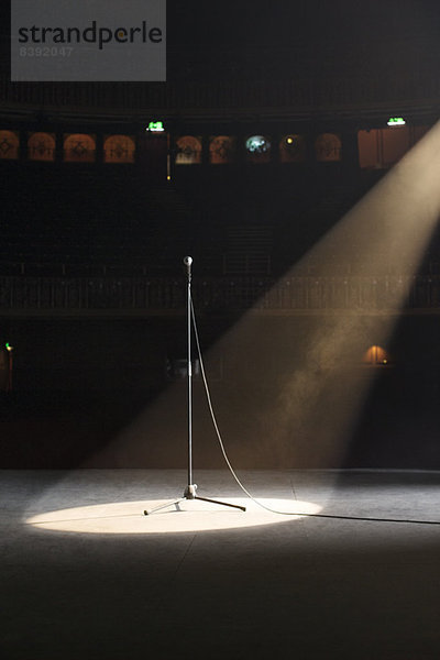 Mikrofon im Rampenlicht auf leerer Theaterbühne