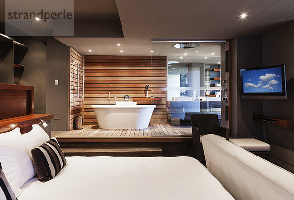 Bett und Badewanne im modernen Hauptschlafzimmer