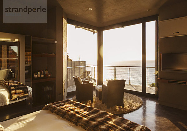 Luxuriöses Schlafzimmer mit Blick auf das Meer bei Sonnenuntergang