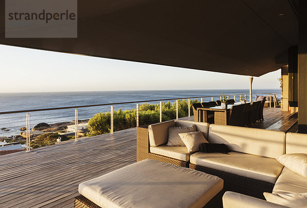 Sofa und Tisch auf luxuriöser Terrasse mit Blick auf den Ozean