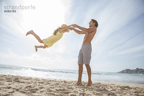 Vater und Tochter spielen am Strand