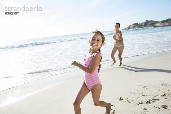 Mutter und Tochter beim Laufen am Strand