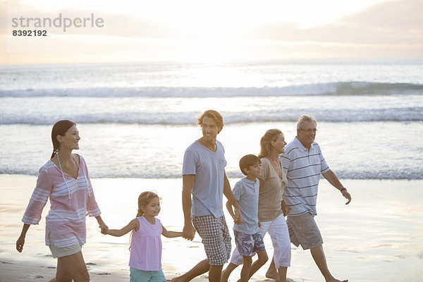Mehrgenerationen-Familie beim gemeinsamen Spaziergang am Strand
