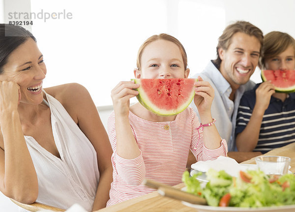 Familie isst Wassermelone bei Tisch