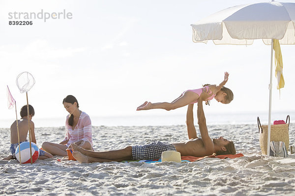 Familie entspannt gemeinsam am Strand