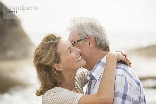 Älteres Ehepaar beim Küssen am Strand