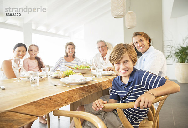 Familie lächelt gemeinsam bei Tisch