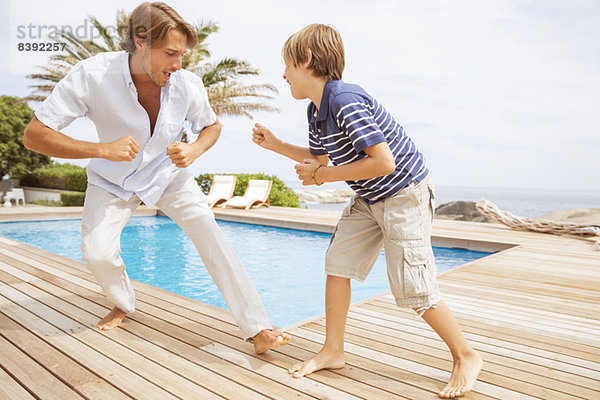 Vater und Sohn spielen am Pool