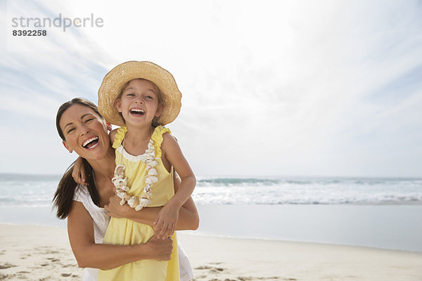Mutter und Tochter lachen am Strand