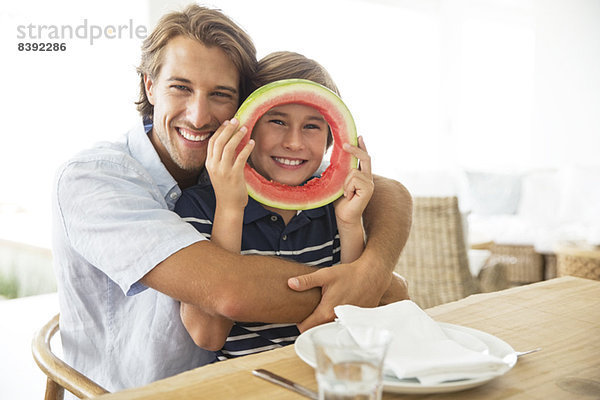 Vater und Sohn spielen mit dem Essen am Tisch