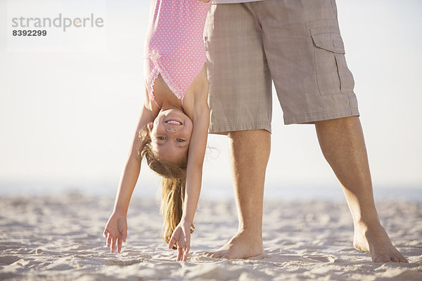 Vater und Tochter spielen am Strand